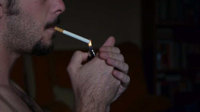 a naked young White man smoke cigarette / profile