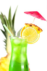 Green tropical cocktail with pineapple, orange and lime slices