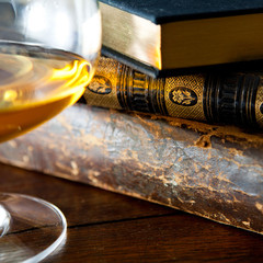 Old books and glass of brandy