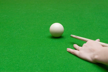 female hand with billiard cue and white ball, selective focus