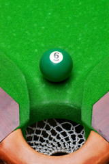 Billiard green ball number six near pocket with selective focus