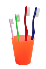 Family of different size toothbrush in a cup isolated on white