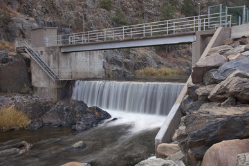 Obraz premium diversion dam on a mountain river flowing in deep, dark canyon