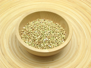 Holzschale mit Buchweizen auf Bambusteller