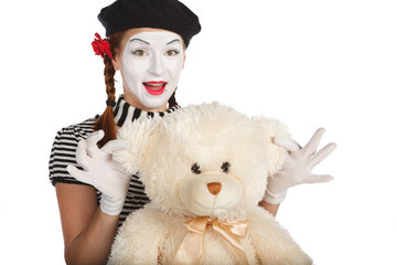 Mime comedian playing with teddy bear