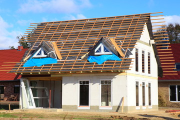 Neubau Einfamilienhaus Dachbalken Rohbau blauer Himmel