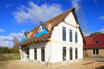 Neubau Einfamilienhaus Dachbalken Rohbau blauer Himmel