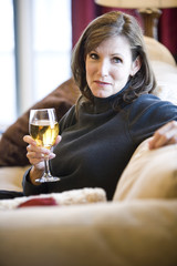 Middle aged woman relaxing on living room sofa