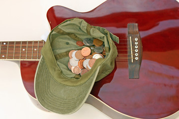 cap full of coins and guitar