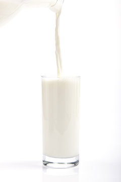A clean and minimalistic image featuring a glass and pitcher of fresh milk against a white background, evoking purity and health.