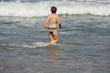 femme d'âge mur en train de marcher dans l'eau