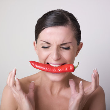 jeune femme nue mangeant un piment rouge