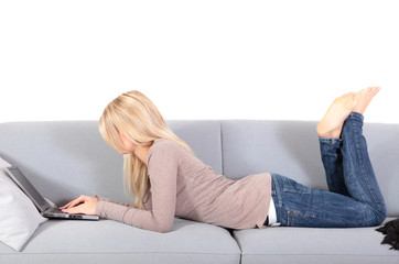 Attraktive Frau nutzt ein Notebook auf der Couch