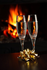 Christmas glasses with champagne, fire as the background