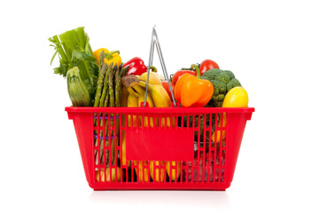 Red shopping basket with vegetables on white