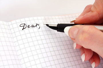 Hand with pen writing a letter