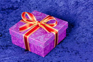 Geschenk mit roter Schleife,auf Königsblau