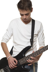The young guy with a bass guitar on a white background.