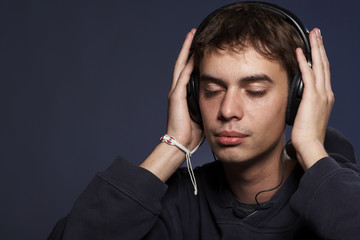 Portrait of the guy listening to music in ear-phones.