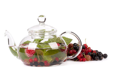 Teapot with fruit tea and green leaves