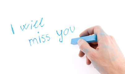 Hand with chalk writing on a white background