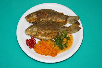 Fried fish in plate on a green background