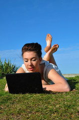 Young Girl works with her laptop in a park