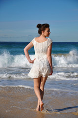 Beautiful young girl runs in the water on Bondi Beach