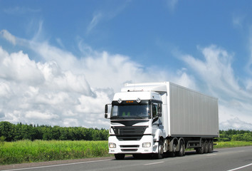 Fototapeta na wymiar biały ciężarówka na autostradzie kraju pod błękitne niebo