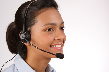 Beautiful young woman providing telephone support with a smile
