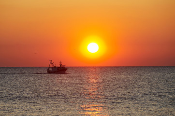 Fototapeta na wymiar Kuter rybacki o zachodzie słońca
