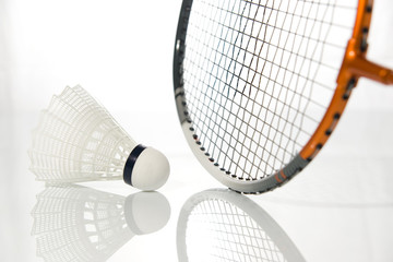Raquette et volant de badminton en gros-plan sur fond blanc