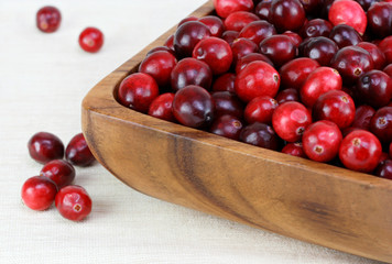Fresh, healthy cranberries in a wooden bowl.