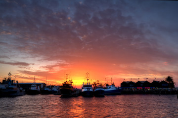 Sun setting between boats in Freo harbour