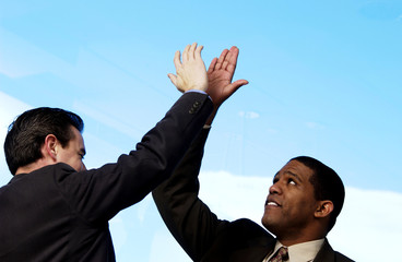 Two businessman giving each other high five