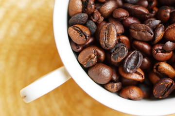 cup filled with freshly roasted coffee beans