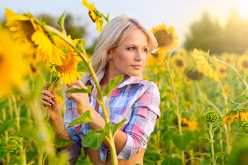 Young blonde girl in a field of sunflowers