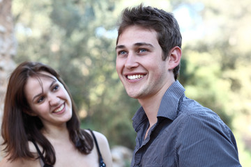 Beautiful young couple outdoors - smiling having fun.
