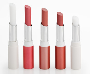 Obraz premium Five Color lipsticks arranged in line isolated on white