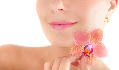 Young beautiful woman with pure skin and orchid flower