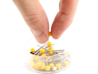 Notions - Box with needles on white background, with a hand