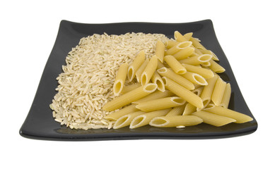brown rice and pasta on black plate on white background