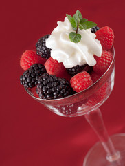 Raspberries and blackberries with whip cream and mint