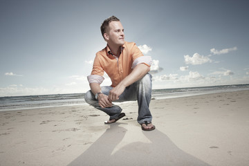 Man squatting on the sand