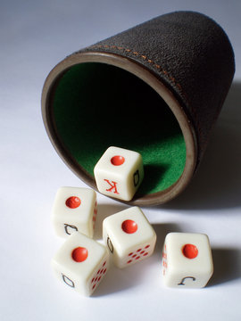 dados saliendo de un cubilete y formando un repoker de ases