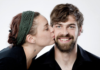 Young woman giving smiling kiss on his cheek