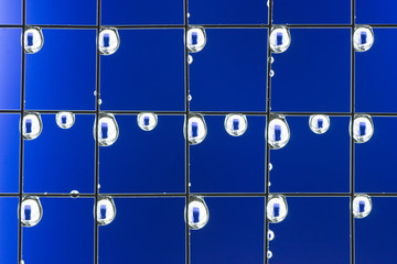 Metal mesh with water drops on the blue background