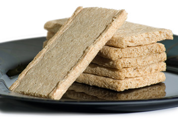 Stack of rye crackers on a plate. Isolated on white.