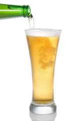 Beer pouring from bottle into glass isolated on white
