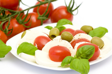 Obraz na płótnie Canvas caprese - Italian salad with cherry tomatoes, olives and mozzare